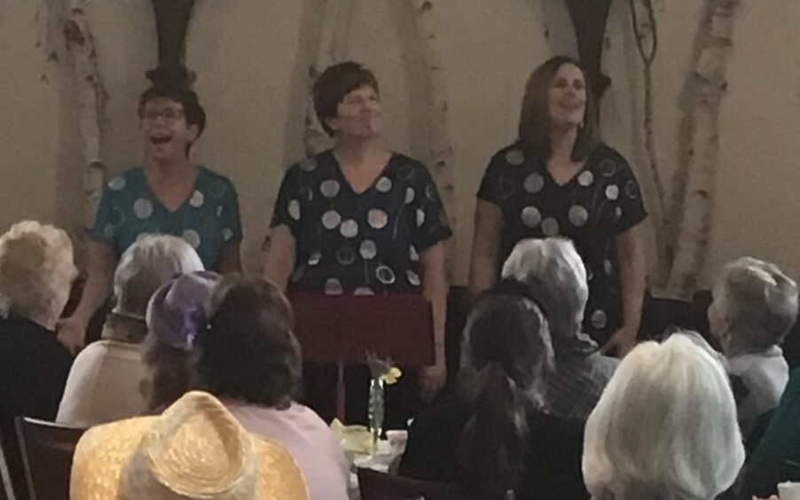 Three women singing during a church event